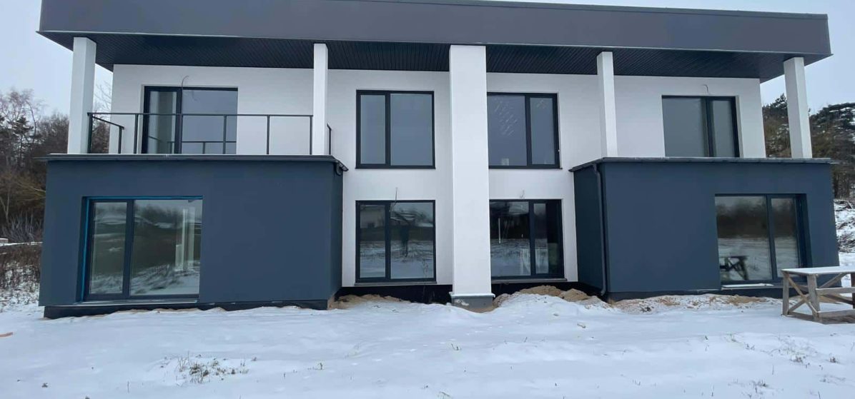 Modern modular home in Lithuania with flat roof and dual-tone render finish