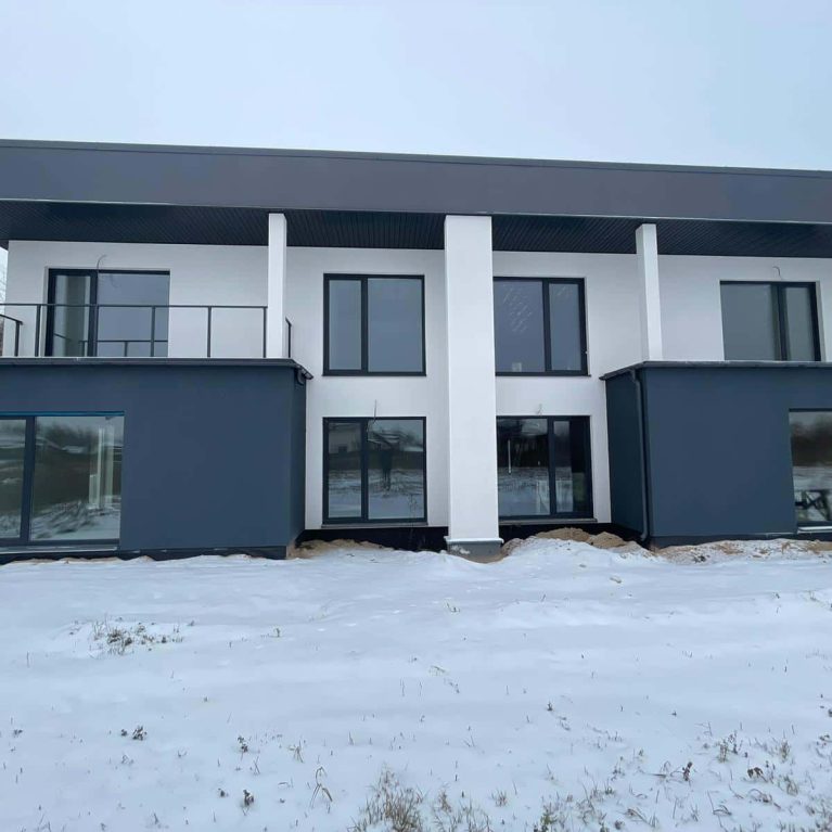 Modern modular home in Lithuania with flat roof and dual-tone render finish