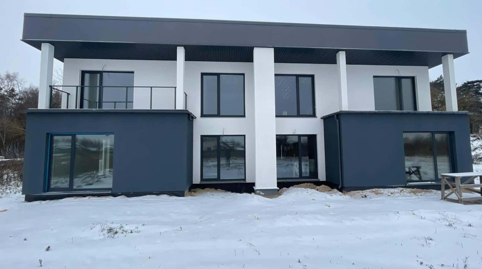 Modern modular home in Lithuania with flat roof and dual-tone render finish